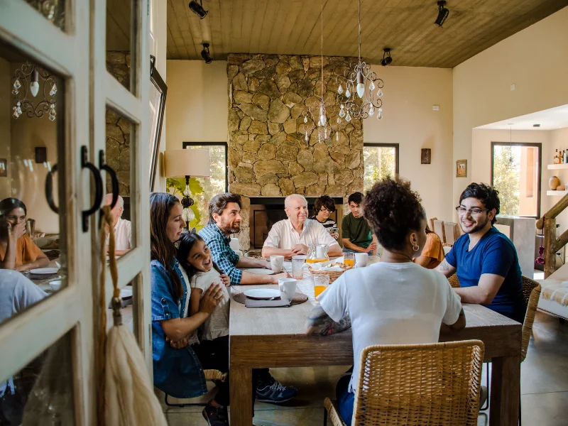 Family and friends sharing a meal around a dining table.