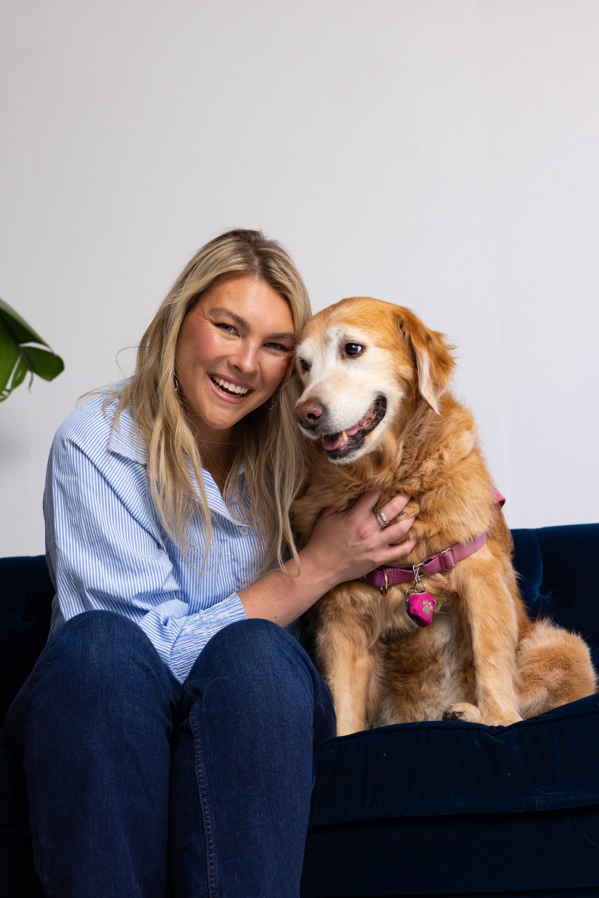 Hannah Snider seated beside Lola on a navy sofa.